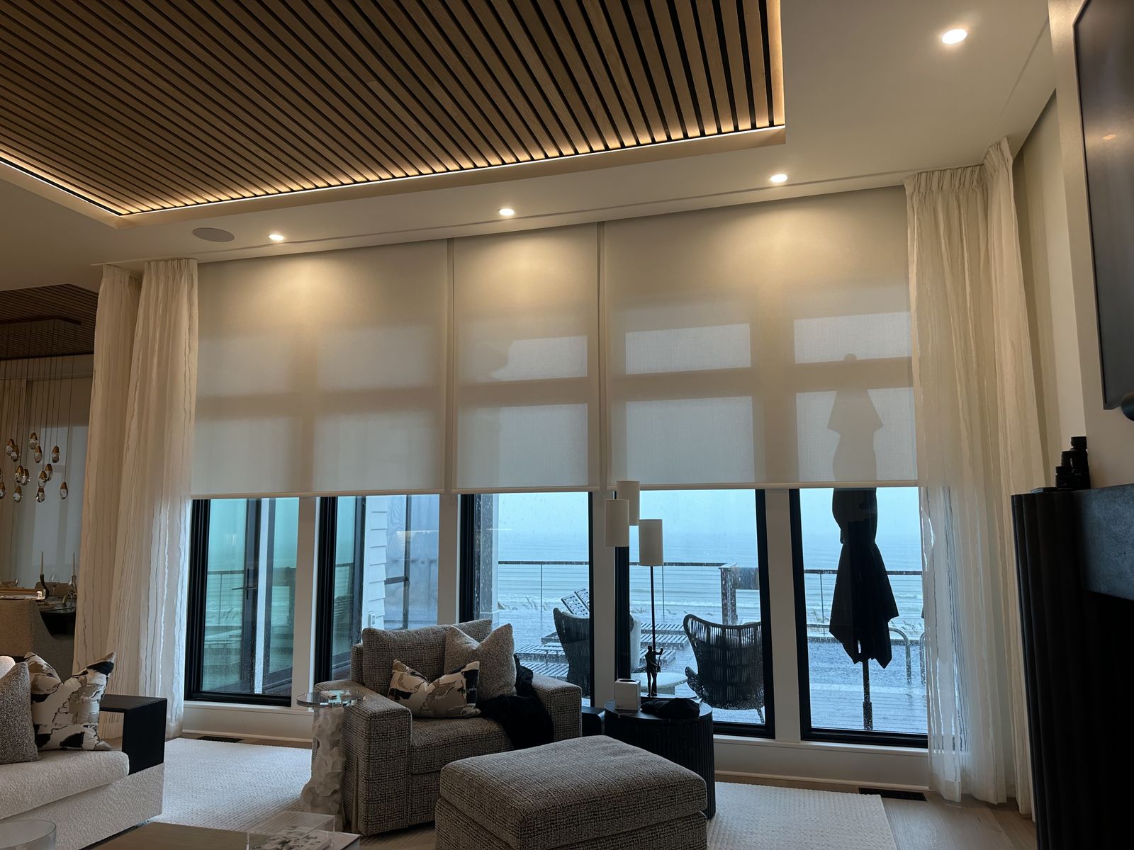 Motorized window shades and recessed lighting in an oceanfront living room